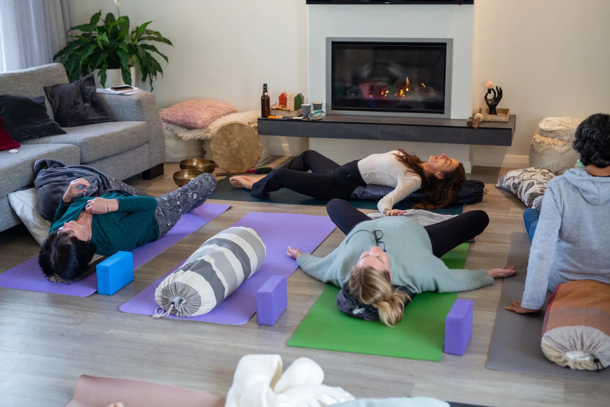 Participants resting in savasana by the fire