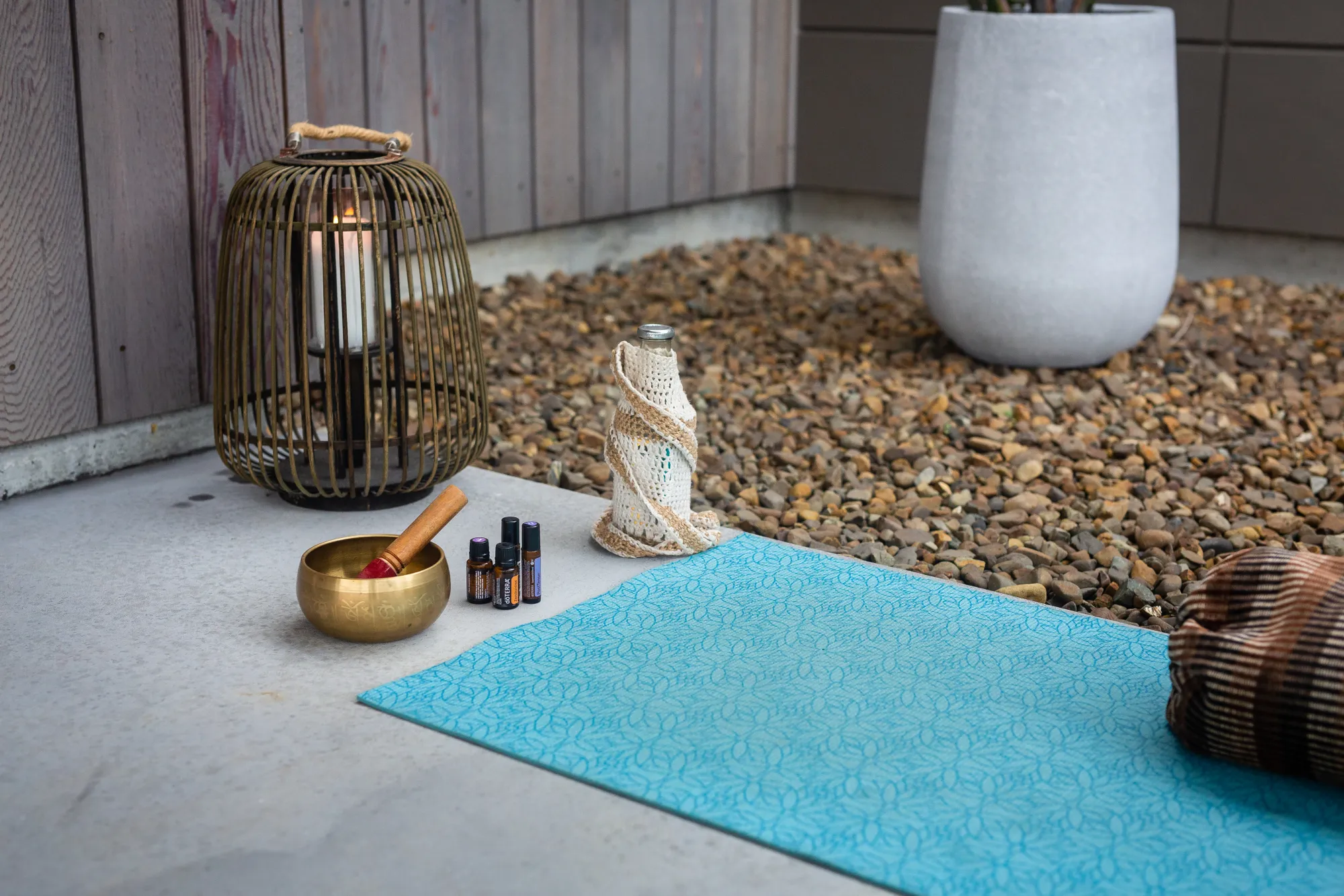 A singing bowl, essential oils and a candle set out for practice